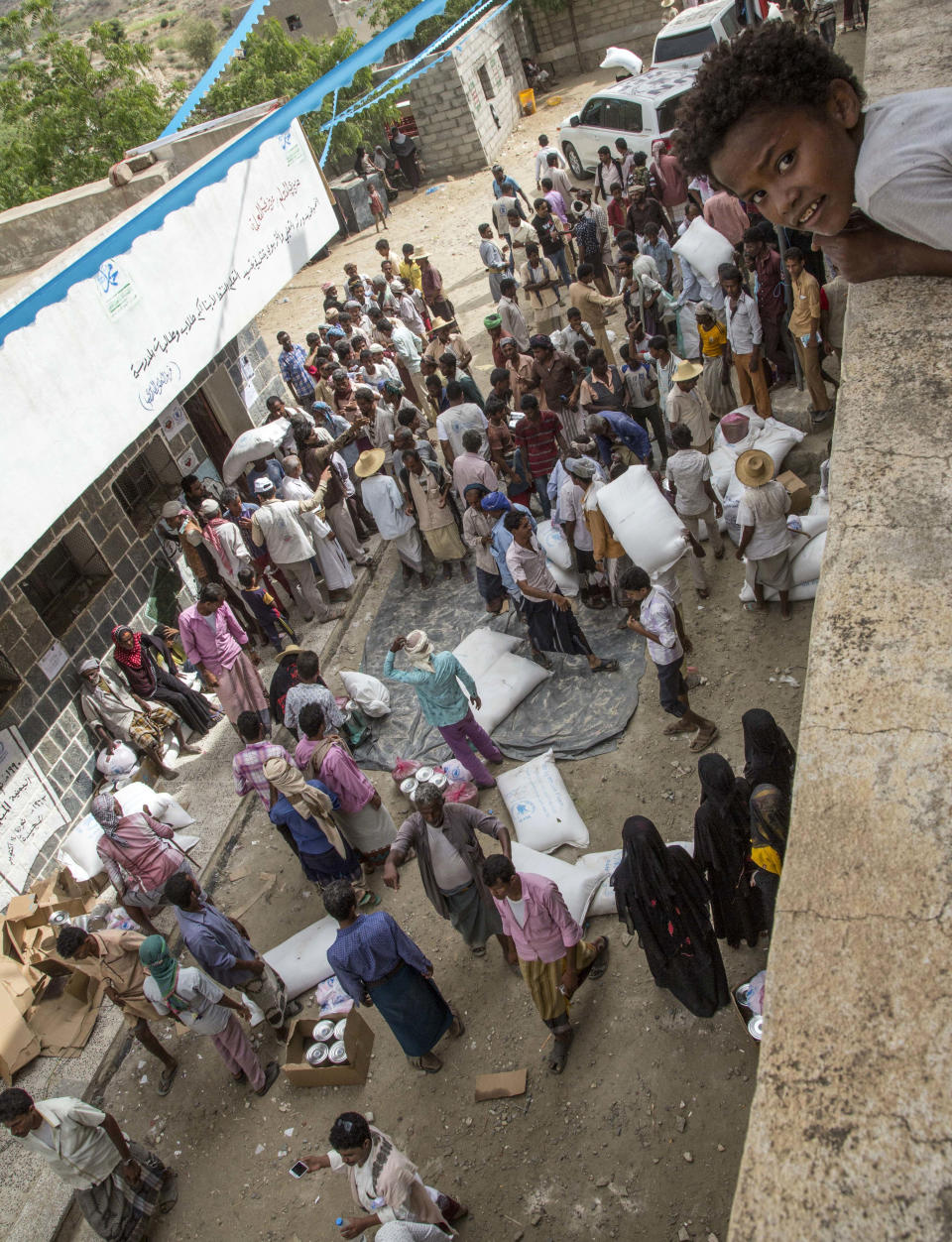 This Nov. 16, 2018 photo shows food distribution by the WFP in Aslem, Yemen. The U.N. food agency said Thursday, Dec. 6, 2018 it is planning to rapidly scale up food distribution to help another 4 million people in Yemen over the next two months, more than a 50-percent increase in the number reached now, if access can be maintained in the poor, war-stricken country". (Marco Frattini/WFP via AP)