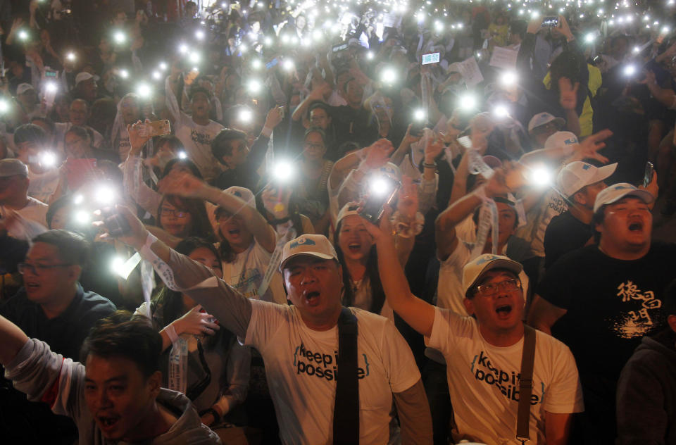 Supporters of Taipei city mayor and city mayoral candidate Ko Wen-je cheer for Ko's victory in Taipei, Taiwan, Sunday early morning, Nov. 25, 2018. Taiwan's ruling party suffered a major defeat Saturday in local elections seen as a referendum on the administration of the island's independence-leaning president amid growing economic and political pressure from China. (AP Photo/Chiang Ying-ying)