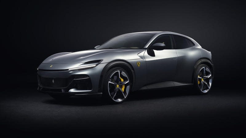 A silver Ferrari Purosangue inside a black studio