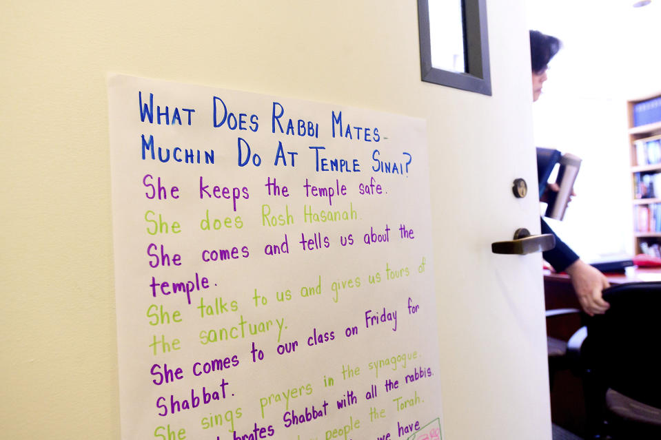 In this Saturday, Feb. 1, 2020, photo, Rabbi Jacqueline Mates-Muchin heads to Shabbat morning service at Temple Sinai in Oakland, Calif. "She keeps the temple safe" leads a list of rabbinical duties posted on her office door. (AP Photo/Noah Berger)