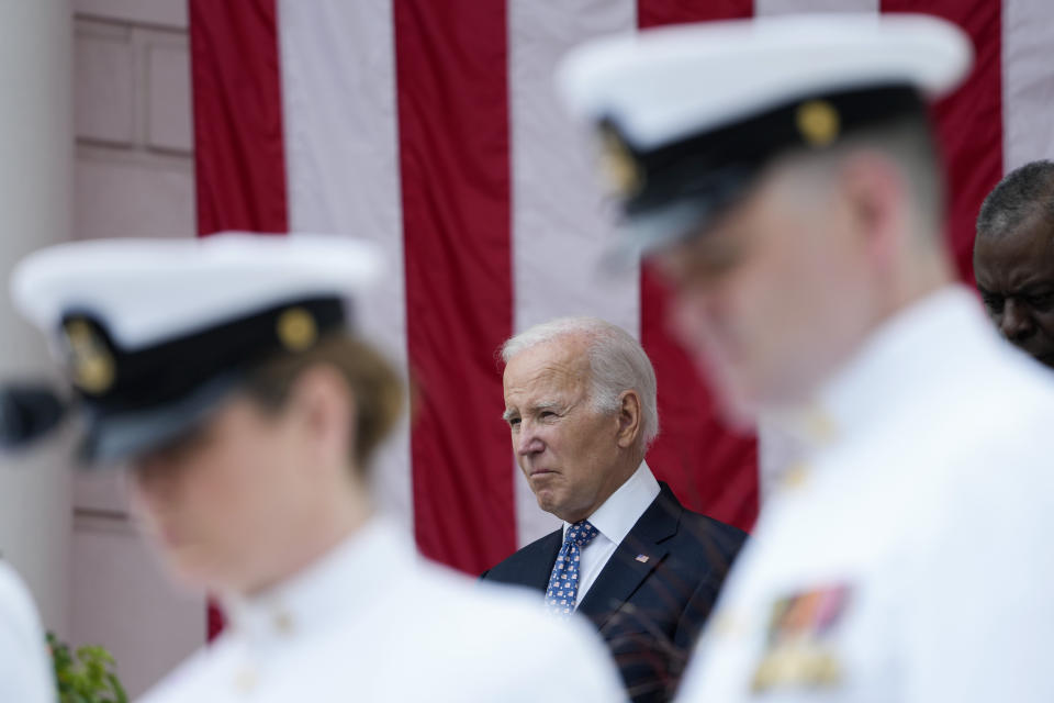 President Joe Biden stands with Defense Secretary Lloyd Austin as the national anthem is played at the Memorial Amphitheater of Arlington National Cemetery in Arlington, Va., on Memorial Day, Monday, May 29, 2023. (AP Photo/Susan Walsh)