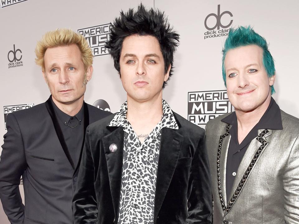 Green Day posing on the red carpet of the 2016 American Music Awards.