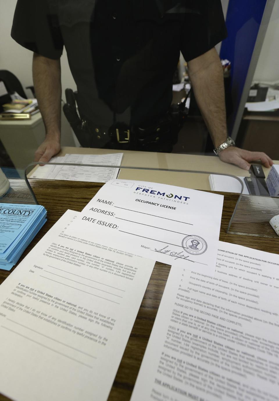 Application forms and an occupancy license certificate are seen at the police station in Fremont, Neb., Wednesday, April 9, 2014, where these licenses will be issued beginning Thursday as part of the city's ordinance aimed at combating illegal immigration. (AP Photo/Nati Harnik)