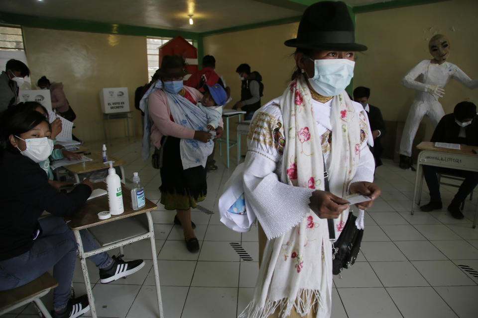 A woman leaves a polling station casting her ballot in a general election, in Cangahua, Ecuador, Sunday, Feb. 7, 2021. Amidst the new coronavirus pandemic, Ecuadoreans went to the polls in a first-round presidential and legislative election. (AP Photo/Dolores Ochoa)