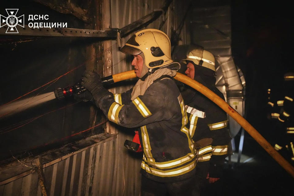 In this photo provided by the Ukrainian Emergency Service, emergency services personnel work to extinguish a fire following a Russian attack in Odesa, Ukraine, Wednesday, May 1, 2024. (Ukrainian Emergency Service via AP)