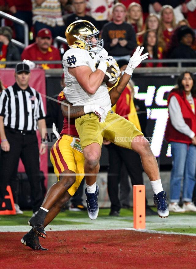 LOS ANGELES, CA - NOVEMBER 26: Notre Dame Fighting Irish tight end Michael Mayer (87) catches a pass for a touchdown in front of USC Trojans defensive back Max Williams (4) during the first half of a college football game played on November 26, 2022 at the Los Angeles Memorial Coliseum in Los Angeles, CA. (Photo by John Cordes/Icon Sportswire) (Icon Sportswire via AP Images)