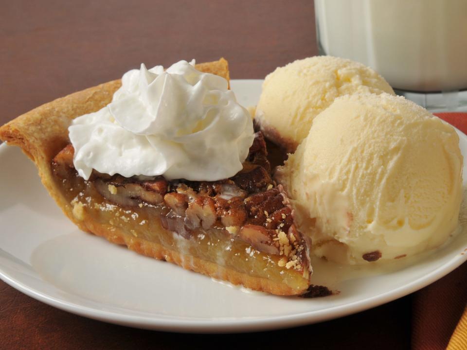 pecan Pie with whipped cream and ice cream on white plate