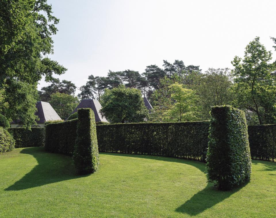 Celebrated Belgian landscape designer Jacques Wirtz designed the garden, with clipped hedges that provide contrast to romantic rambling vines and loosely arranged greenery.