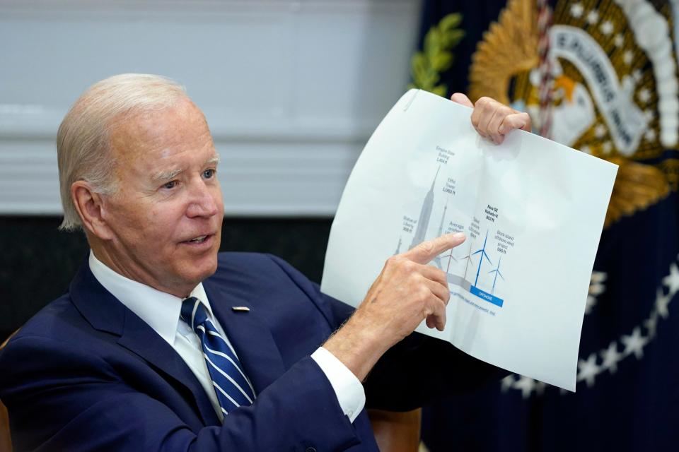 President Joe Biden shows a wind turbine size comparison chart during a meeting in the Roosevelt Room of the White House in Washington, June 23, 2022, with governors, labor leaders, and private companies launching the Federal-State Offshore Wind Implementation Partnership.
