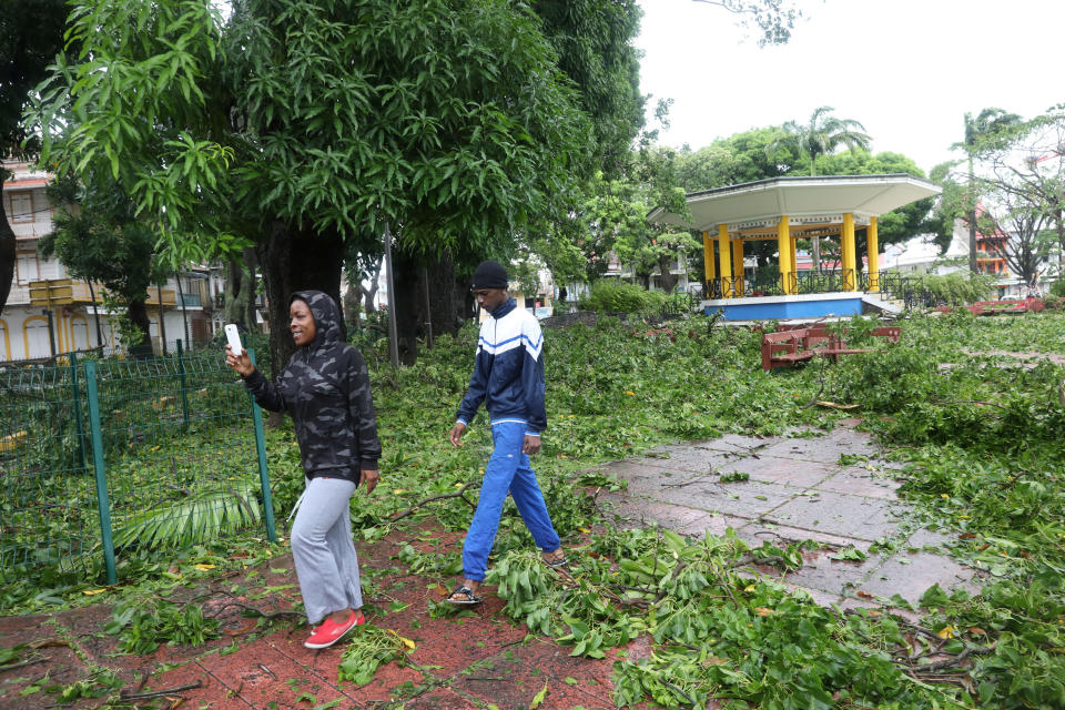 People walk amid fallen branches in a square after the passage of Hurricane Maria in Pointe-a-Pitre, Guadeloupe, on Sept. 19, 2017.