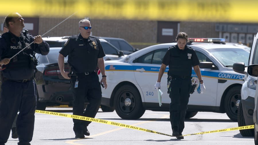 Baltimore Police Forensic Service officers inspects an area where two officers on the U.S. Marshals' task force were allegedly shot in Baltimore, according to officials, Tuesday, July 13, 2021