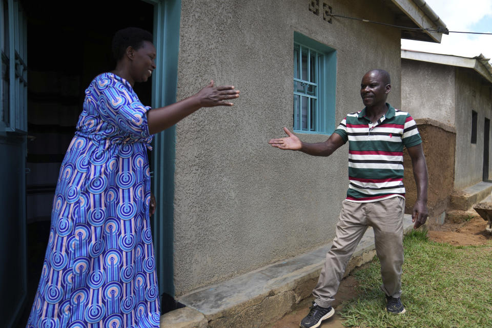 Genocide survivor Jeanette Nyirabashyitsi, 45, left a Tutsi, greets Frederick Kazigwemo, a Hutu who was jailed for nine years for genocide-related crimes in the reconciliation village of Mbyo, in Nyamata, Rwanda Friday, April 5, 2024. Thirty years after the genocide, the country has fourteen "reconciliation villages" where convicted perpetrators who have been released from prison after publicly apologizing for their crimes live side by side with genocide survivors. (AP Photo/Brian Inganga)