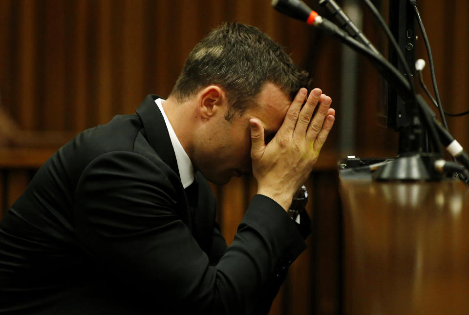 Oscar Pistorius sits with his head in his hands in the dock on the third day of his trial at the high court in Pretoria, South Africa, Wednesday, March 5, 2014. Pistorius is charged with murder for the shooting death of his girlfriend, Reeva Steenkamp, on Valentine's Day in 2013. (AP Photo/Siphiwe Sibeko, Pool)