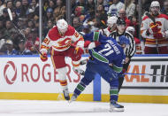 Calgary Flames' Kevin Rooney, left, and Vancouver Canucks' Nils Hoglander collide during the third period of an NHL hockey game Tuesday, April 16, 2024, in Vancouver, British Columbia. (Darryl Dyck/The Canadian Press via AP)