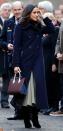 <p>Meghan attended her first public appearance with Prince Harry in Nottingham wearing an all-British/Amercian fashion ensemble comprising of a double-breasted Mackage navy coat, Joseph skirt and carried a burgundy and navy blue Strathberry handbag. </p>