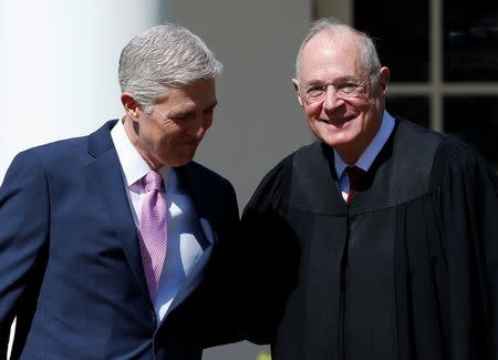 Judge Neil Gorsuch greets Justice Anthony Kennedy before being sworn in as an Associate Supreme Court Justice in the Rose Garden of the White House in Washington, U.S., April 10, 2017. REUTERS/Joshua Roberts