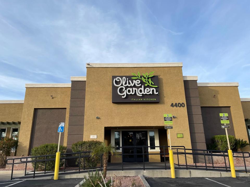 Exterior of Olive Garden. The building is light brown and the skies above are bright-blue