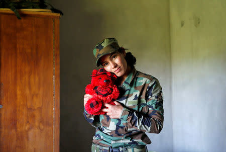 Yazidi female fighter Asema Dahir, 21, poses with a teddy bear in a bedroom at a site near the frontline of the fight against Islamic State militants in Nawaran near Mosul, Iraq, April 20, 2016. REUTERS/Ahmed Jadallah