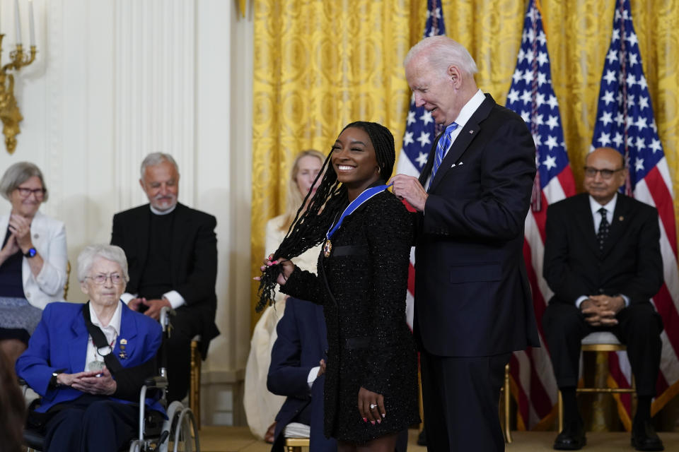 President Joe Biden awards the nation's highest civilian honor, the Presidential Medal of Freedom, to gymnast Simone Biles during a ceremony in the East Room of the White House in Washington, Thursday, July 7, 2022. Biles is the most decorated U.S. gymnast in history, winning 32 Olympic and World Championship medals, and is an advocate on issues including athletes' mental health, children in foster care and sexual assault victims. (AP Photo/Susan Walsh)