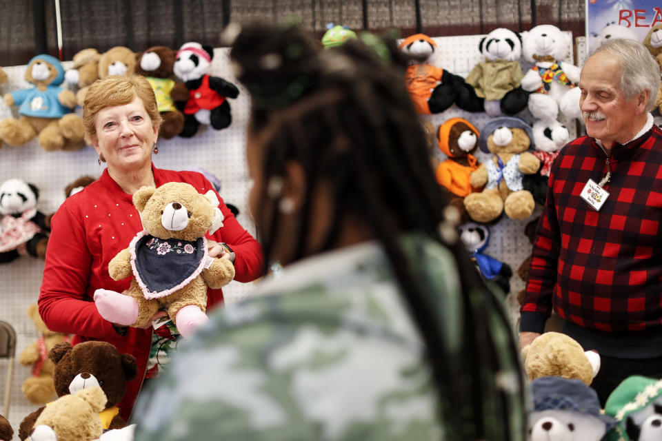Workers help parents browse tables of donated holiday toys and stuffed animals at the Salvation Army Toy Shop, Tuesday, Dec. 11, 2018, in Cincinnati. (AP Photo/John Minchillo)