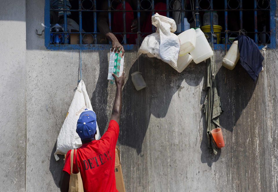 <p>A prisoner sells cigarettes to a fellow inmate at the National Penitentiary in downtown Port-au-Prince, Haiti, Feb. 13, 2017. Prison authorities say they try their best to meet inmates’ needs, but repeatedly receive insufficient funds from the state to buy food and cooking fuel. Some inmates are provided meals by visiting relatives and others are permitted by guards to meet with contacts to bring in food, cigarettes and other things. (Photo: Dieu Nalio Chery/AP) </p>