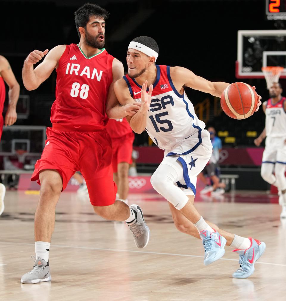 Devin Booker drives to the basket while being defended by Iran's Behnam Yakhchalidehkordi.