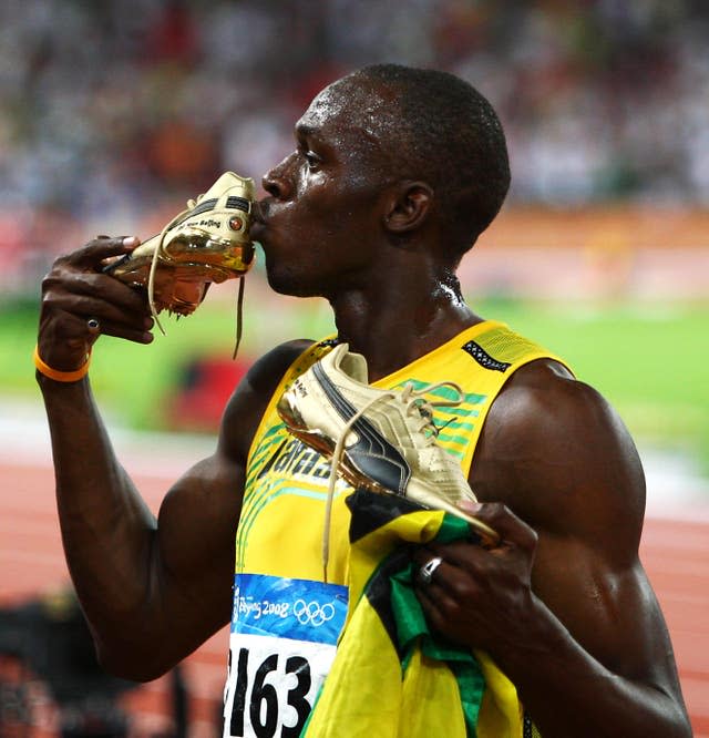 Usain Bolt kisses his golden shoe after the race