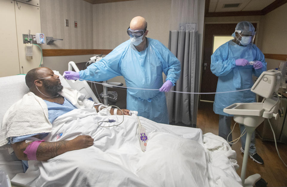 Medical personnel check the temperature of COVID-19 patient Cedric Daniels, 37, of Gonzales, La., at Our Lady of the Lake Regional Medical Center in Baton Rouge, Monday, Aug. 2, 2021. Louisiana is leading the nation in the number of new COVID cases per capita and remains one of the bottom five states in administering vaccinations. (AP Photo/Ted Jackson)