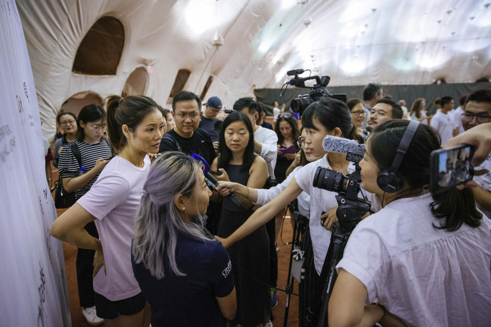 Two-time Grand Slam champion Li Na, left, talks to members of the media at the Sutton East Tennis Club Thursday, July 18, 2019, in New York. Li Na will be inducted into the Tennis Hall of Fame on Saturday, July 20. (AP Photo/Kevin Hagen)