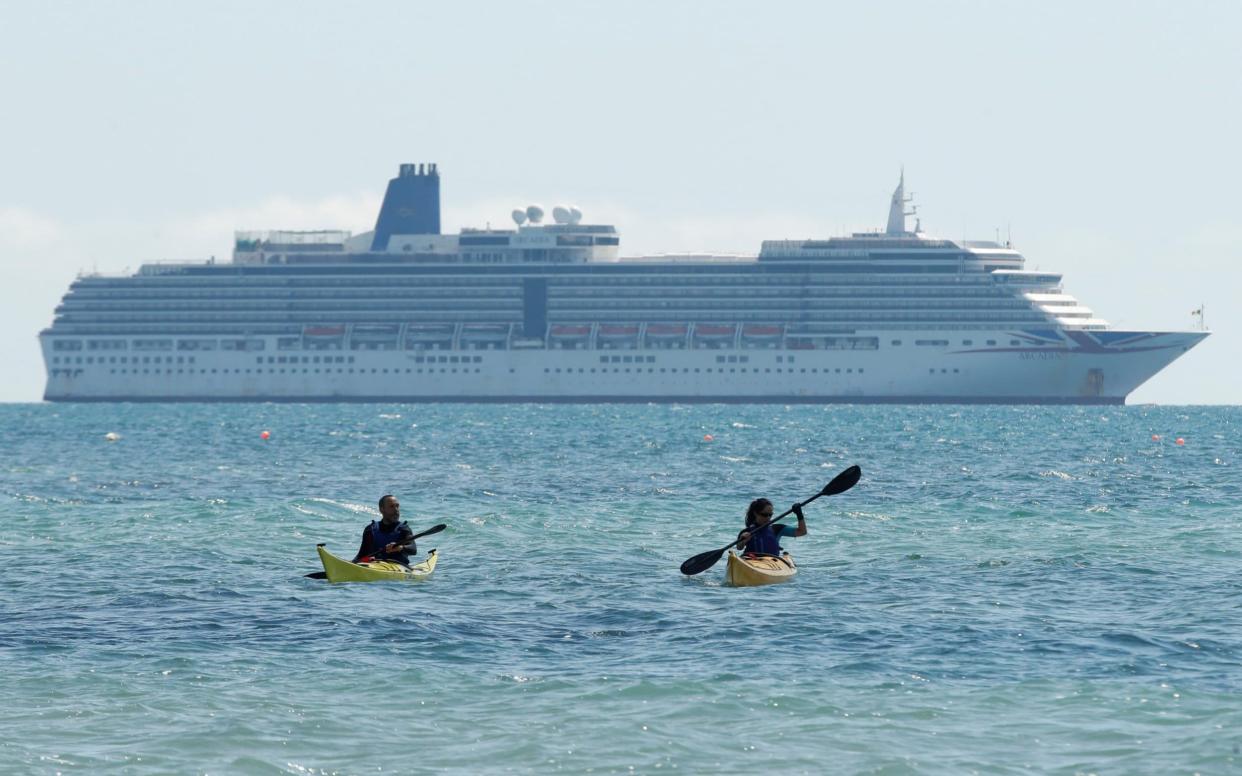 Kayakers are seen in front of Arcadia cruise ship in Weymouth, following the outbreak of the coronavirus disease (COVID-19), Weymouth, Britain, May 18, 2020 - REUTERS/Matthew Childs