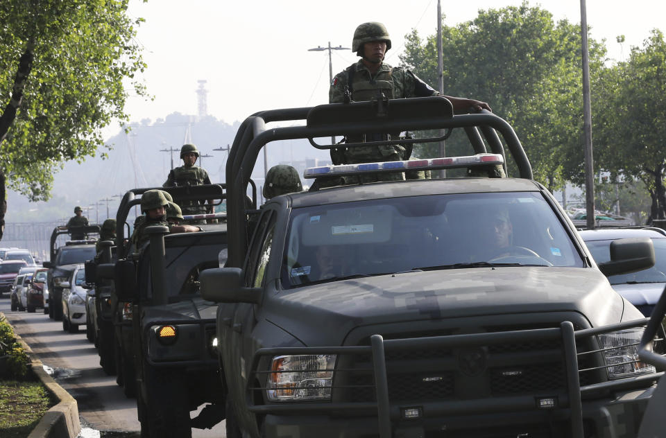 CORRECTS PRESENCE OF NATIONAL GUARD - Members of Mexico's newly-formed National Guard patrol near a federal police command center taken over by striking police in the Iztapalapa borough, in Mexico City, Thursday, July 4, 2019, who are protesting against plans to force them into the newly formed National Guard. Security Secretary Alfonso Durazo said the National Guard presence in Iztapalapa had nothing to do with the striking police. He said they had been deployed there to fight crime and were patrolling in the area. (AP Photo/Marco Ugarte)