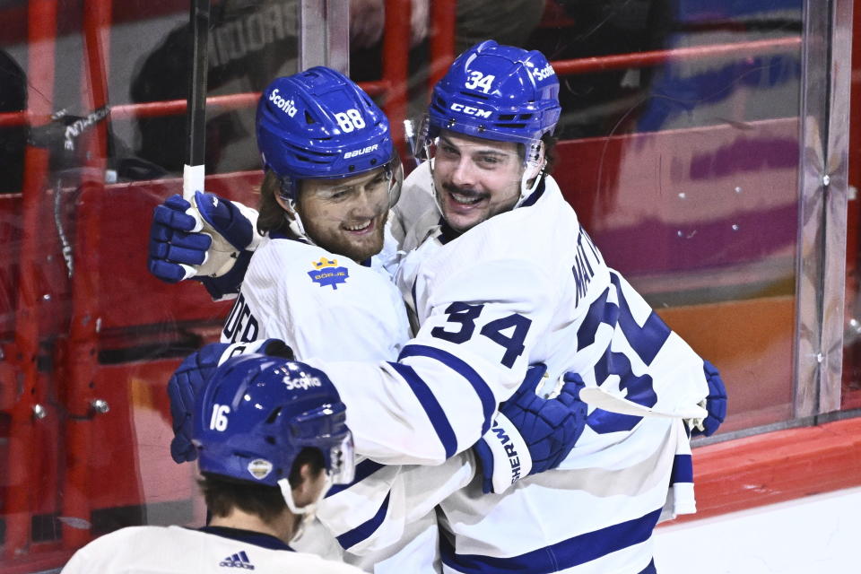 Toronto's Auston Matthews, center, celebrates scoring with teammate William Nylander during the NHL Global Series Sweden ice hockey match between Toronto Maple Leafs and Minnesota Wild at Avicii Arena in Stockholm, Sweden, Sunday, Nov. 19, 2023.(Claudio Bresciani/TT via AP)