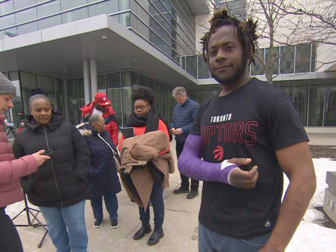 Devin Fowlin, right, spoke with reporters Wednesday after he was shot by Toronto police in February. (Martin Trainor/CBC - image credit)