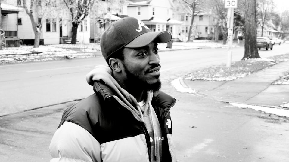 Anthony Miller stands on the corner of Roslyn Street and Genesee Street, where he was identified as the gunman who robbed Jack Moseley.