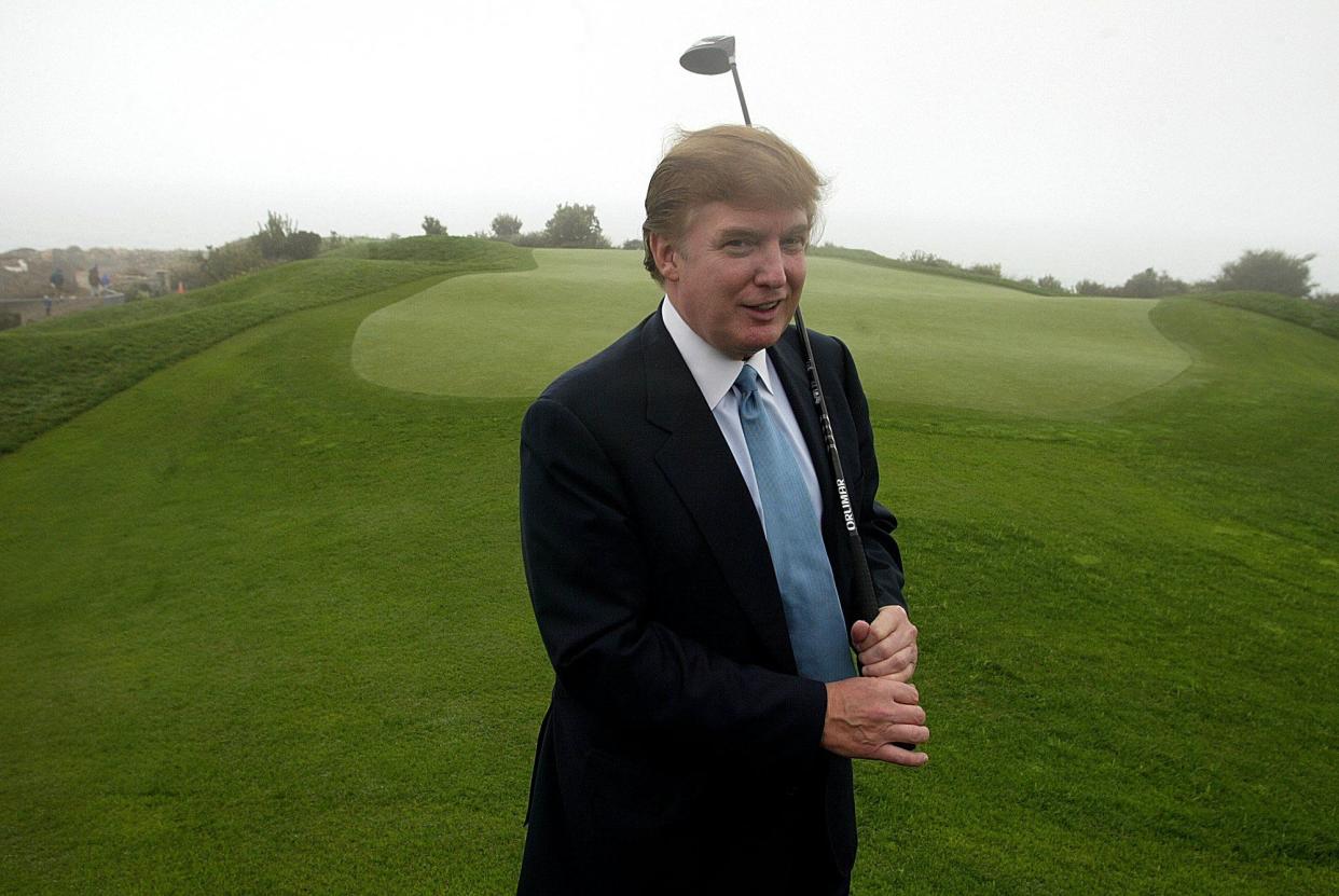 Donald Trump holds a driver on the 11th green of his Ocean Trails Golf Club in Rancho Palos Verdes, Calif. on Saturday, Nov. 9, 2002.