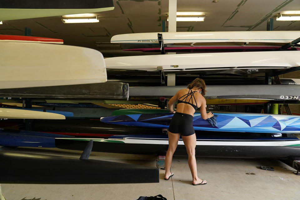 Canoe sprint world champion Nevin Harrison, 19, of Seattle, cleans her boat before she trains near Lake Lanier Olympic Park on Thursday, July 1, 2021, in Gainesville, Ga. Harrison won the world championship in the women's sprint canoe 200 meters as a 17-year-old in 2019. Now she'll try to duplicate that at the Olympics in Tokyo where the race will be a new event in a bid for gender equity. (AP Photo/Brynn Anderson)