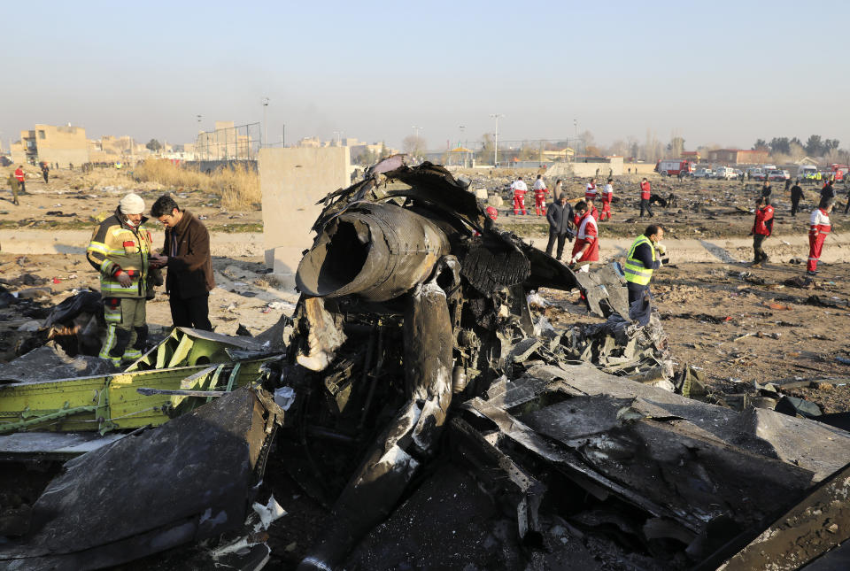 Debris is seen from an Ukrainian plane which crashed as authorities work at the scene in Shahedshahr, southwest of the capital Tehran, Iran, Wednesday, Jan. 8, 2020. A Ukrainian airplane carrying 176 people crashed on Wednesday shortly after takeoff from Tehran's main airport, killing all onboard. (AP Photo/Ebrahim Noroozi)