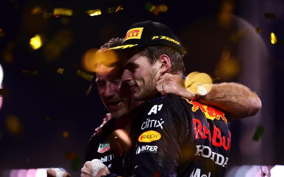Race winner and 2021 F1 World Drivers Champion Max Verstappen of Netherlands and Red Bull Racing celebrates with Red Bull Racing Team Principal Christian Horner on the podium during the F1 Grand Prix of Abu Dhabi at Yas Marina Circuit on December 12, 2021 in Abu Dhabi, United Arab Emirates - Getty Images/Mario Renzi