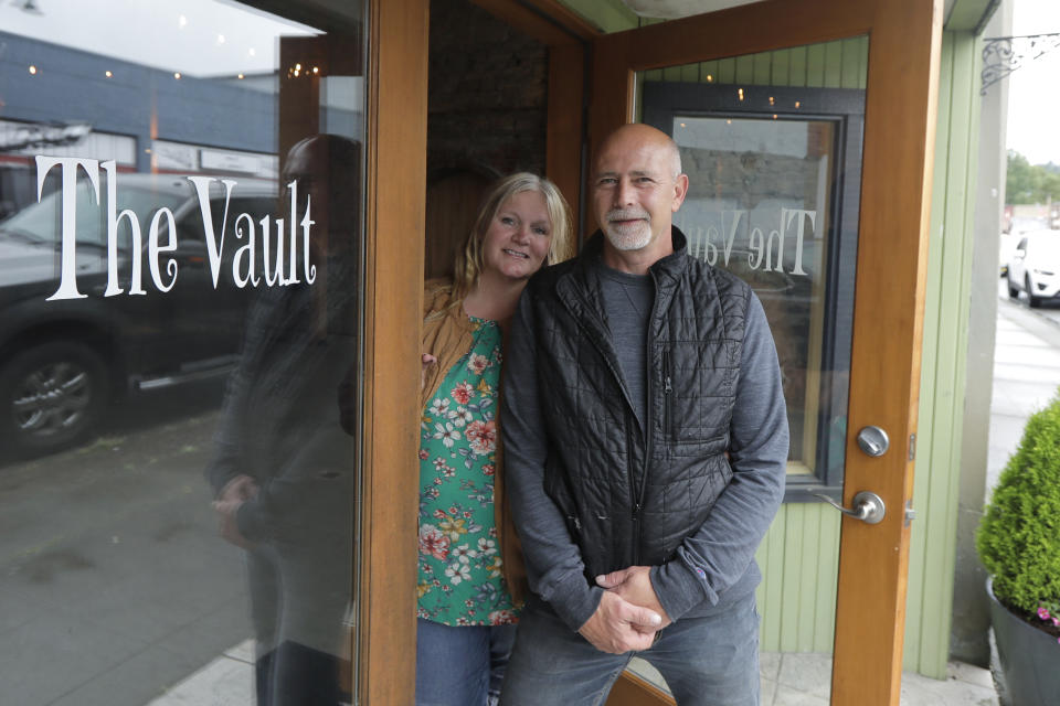 Stephanie Skoglund poses for a photo with her husband, Rick, in the main entrance to The Vault, the wedding and event center she owns in Tenino, Wash., on July 1, 2020. Skoglund's schedule at her two wedding and event venues was packed with dozens of events before the coronavirus outbreak forced her to close her doors in mid-March and left her business, like so many others, on the brink. (AP Photo/Ted S. Warren)