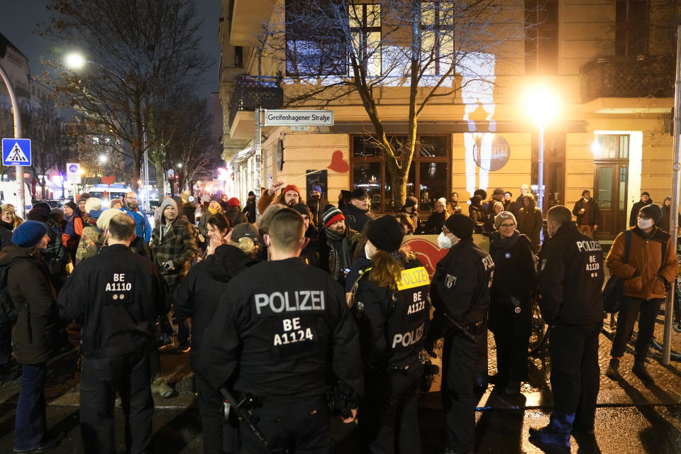 Police officers block anti-vaccination activists who are trying to disturb a counter demonstration in Berlin, Germany, Monday, Jan. 24, 2022. A growing number of Germans have recently joined grassroots initiatives, local groups and spontaneous demonstrations to speak out against vaccination opponents, conspiracy theorists and far-right extremists who have led protests against COVID-19 measures in Germany. (AP Photo/Markus Schreiber)