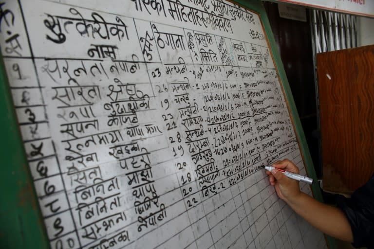 A health worker writes the name of a new mother on a board at a health centre in Ramechhap district, east of Kathmandu