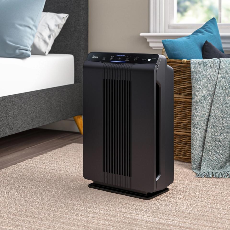 a black air purifier in a bedroom