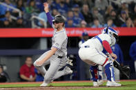 Colorado Rockies' Ryan McMahon, left, slides to score past Toronto Blue Jays catcher Alejandro Kirk, right, during third-inning baseball game action in Toronto, Friday, April 12, 2024. (Frank Gunn/The Canadian Press via AP)