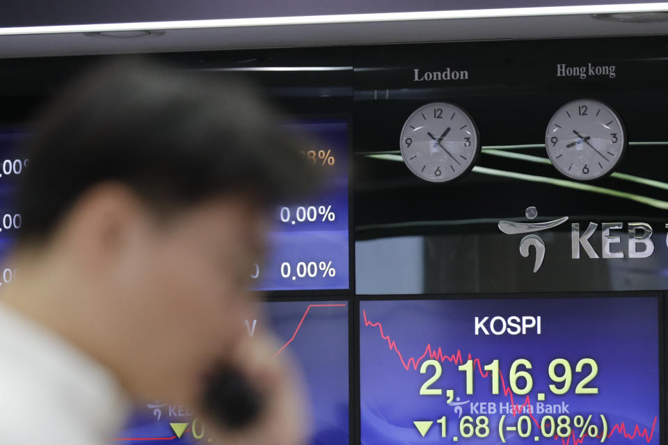 A currency trader talks on the phone near the screen showing the Korea Composite Stock Price Index (KOSPI) at the foreign exchange dealing room in Seoul, South Korea, Friday, Nov. 29, 2019. Shares extended losses in Asia on Friday after Japan and South Korea reported weak manufacturing data that suggest a worsening toll from trade tensions. (AP Photo/Lee Jin-man)