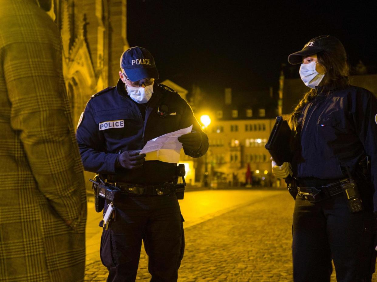 French police check a mobility form required by citizens to go outside of their homes, in an effort to stem the spread of coronavirus: SEBASTIEN BOZON/AFP via Getty Images