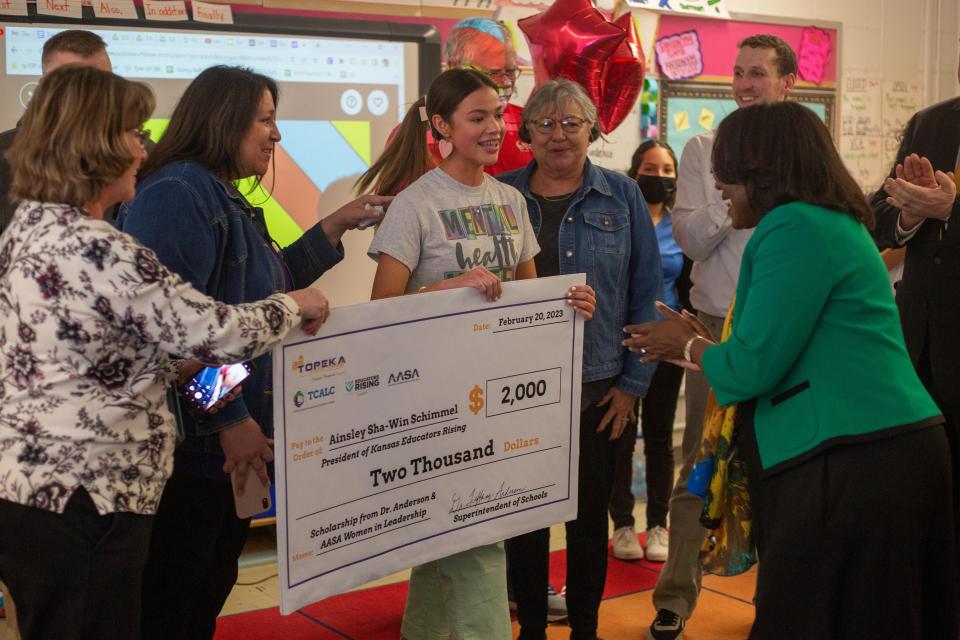 Ainsley Sha-Win Schimmel, a Topeka West senior and member of the Prairie Band Potawatomi Nation, receives a $2,000 scholarship check from Topeka USD 501 superintendent Tiffany Anderson on Monday afternoon at Quincy Elementary School.