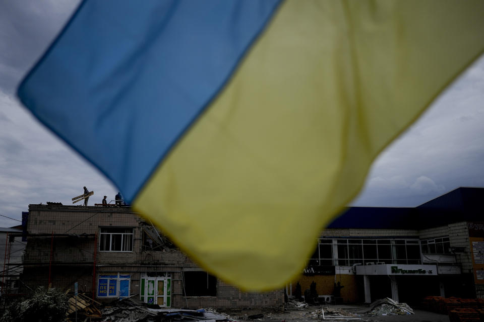 Men work at repairing a building damaged by shelling in Makariv, on the outskirts of Kyiv, Ukraine, Friday, May 27, 2022. (AP Photo/Natacha Pisarenko)