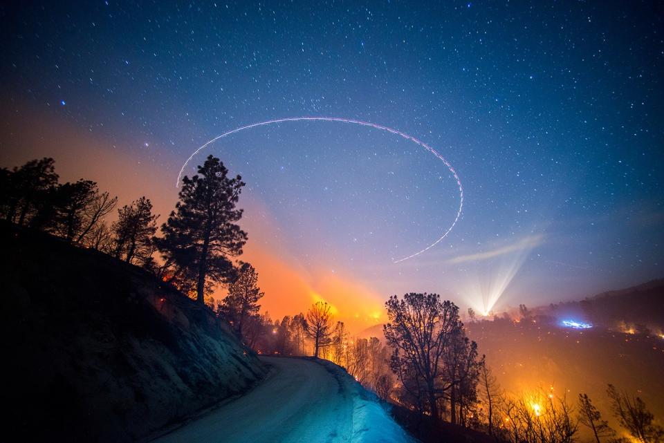 June, 2014. The Shirley Fire burns at night off of Old State Rd near Lake Isabella. A helicopter circles overhead and crews work on a slopover.