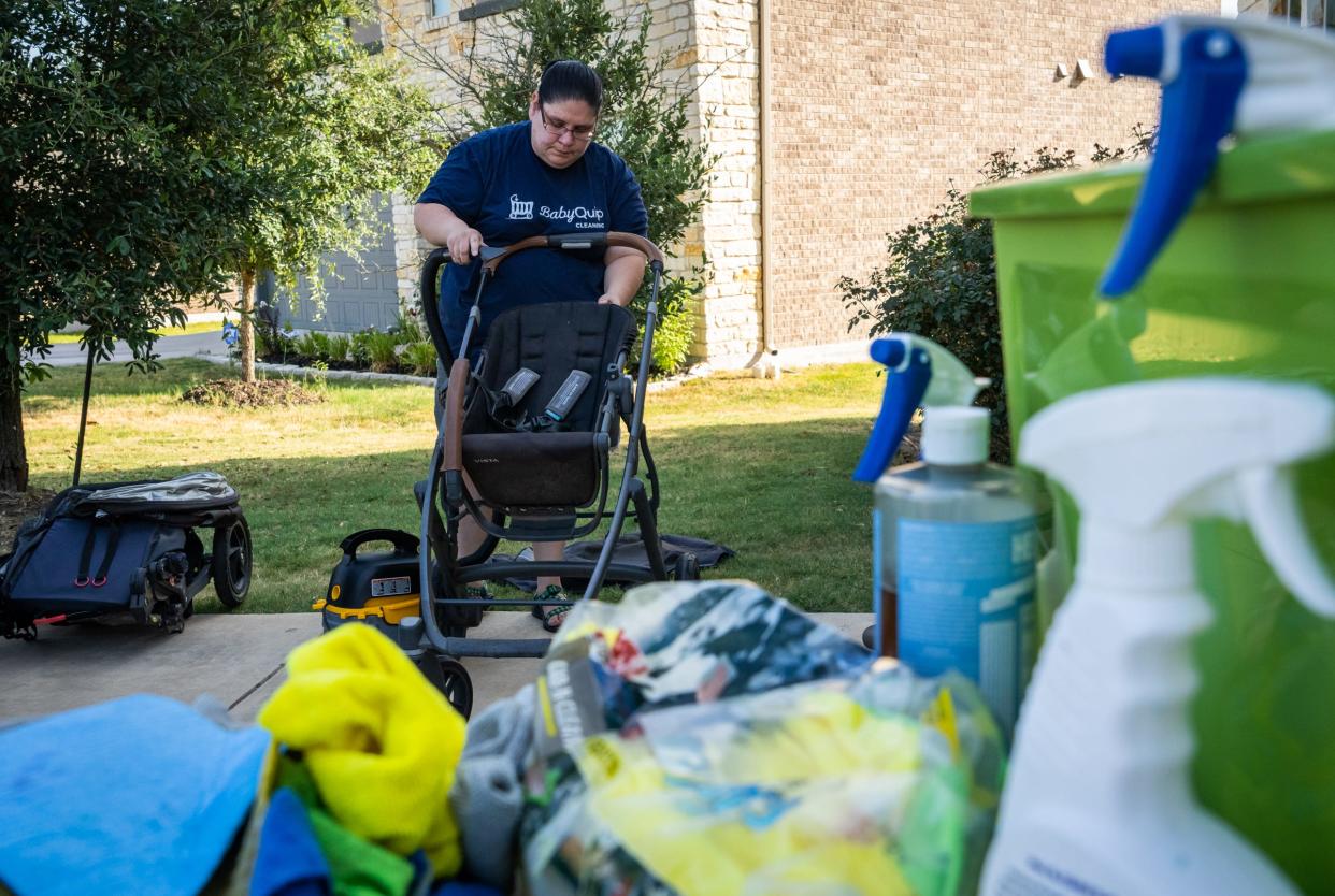 Teresa Valdez, a sixth grade teacher at Perez Elementary School, cleans a stroller on her driveway last week as part of her BabyQuip Cleaning business. Valdez supplements her income over the summer with a variety of odd jobs, including cleaning baby strollers and carriers.