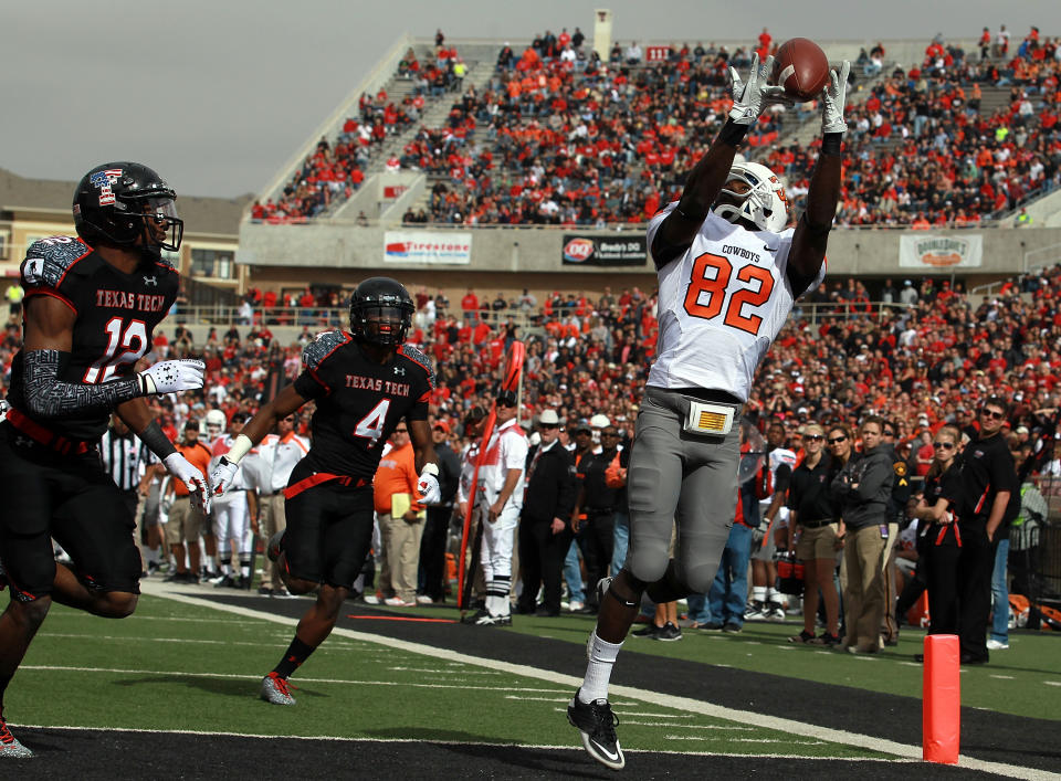 LUBBOCK, TX - NOVEMBER 12: Isaiah Anderson #82 of the Oklahoma State Cowboys makes a touchdown pass against D.J. Johnson #12 of the Texas Tech Red Raiders at Jones AT&T Stadium on November 12, 2011 in Lubbock, Texas. (Photo by Ronald Martinez/Getty Images)